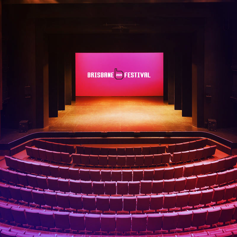 An empty theatre with the Brisbane Festival logo displayed on the stage screen.