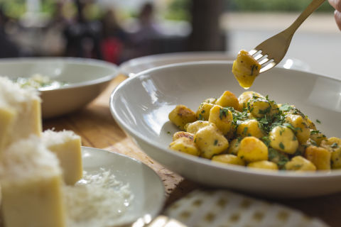 Gnocchi served next to a platter of cheeses. 